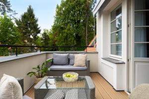 a balcony with a couch and a table at Willa Szwarc by Elite Apartments in Sopot