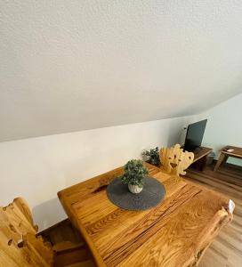 uma mesa de madeira com um vaso de plantas em cima em Rooms Murka em Bled