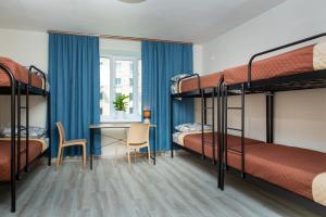 a bedroom with bunk beds and a desk and a table at Хостел єЖитло Щекавиця in Kyiv