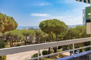 een balkon met bomen en de oceaan op de achtergrond bij Les Magnolies in Platja  d'Aro