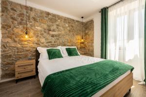 a bedroom with a bed and a stone wall at Villa Antani with heated pool, sauna & jacuzzi in Crikvenica