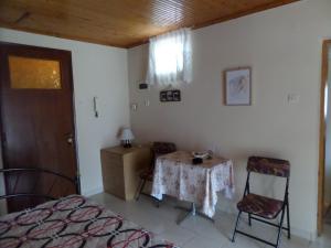 um quarto com uma mesa, uma cama e uma janela em An Entire studio- Farida-Free Parking-Wifi em Xirokámbion