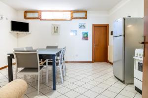 a kitchen with a table and a refrigerator at Sulle Note Del Mare in Follonica