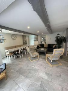 a large living room with chairs and a table at La Maison Bleue, proche de tout in Le Tréport