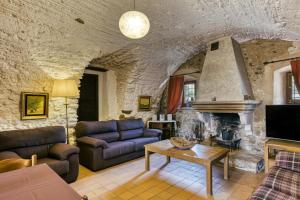 a living room with a couch and a fireplace at La Masía Grande de Can Gat Vell in Llampaies