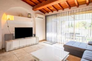 a living room with a tv and a large window at Le Mas d Emponse avec piscine in Plan-de-la-Tour