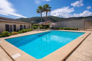 una piscina en un patio con palmeras en Le Mas d Emponse en Plan-de-la-Tour