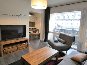 a living room with a television and a couch and a table at Appartement Saint-Lary-Soulan, 2 pièces, 4 personnes - FR-1-457-282 in Saint-Lary-Soulan