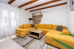salon z żółtą kanapą i stołem w obiekcie Villa Antani with heated pool, sauna & jacuzzi w Crikvenicy