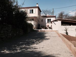 a white house with a driveway in front of it at Villa Roquefortoise avec piscine in Roquefort-les-Pins