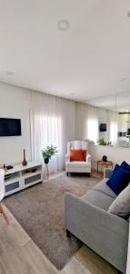 a living room with a couch and a tv at Ninho Citadino Aveiro in Aveiro