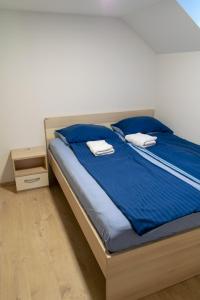 a bed with blue sheets and white towels on it at Hiša Izabela in Muta