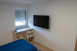 a bedroom with a bed and a television on the wall at Hiša Izabela in Muta