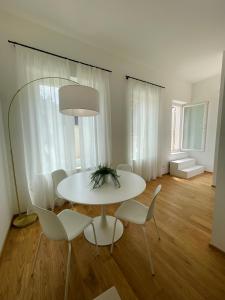 a white dining room with a table and chairs at A un passo dalla piazza in Ascoli Piceno