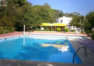 een zwembad met blauw water voor een huis bij Les Magnolies in Platja  d'Aro