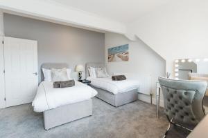 a bedroom with two beds and a chair in it at Birkby Lodge Escape in Lytham St Annes