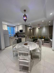 a kitchen and dining room with a white table and chairs at Dar El HABIB in Douar el Hafey