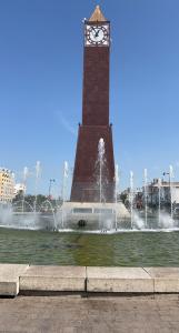 une grande tour d'horloge avec une horloge au milieu d'une fontaine dans l'établissement Dar El HABIB, à Douar el Hafey