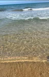 a body of water with the sand and waves at Dar El HABIB in Douar el Hafey