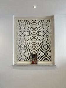 a window in a white wall with a box on a shelf at Dar El HABIB in Douar el Hafey