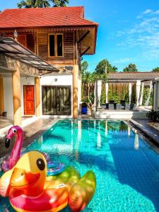 - une piscine avec un flotteur au milieu d'une maison dans l'établissement Avita Pool Villa, à Sichon
