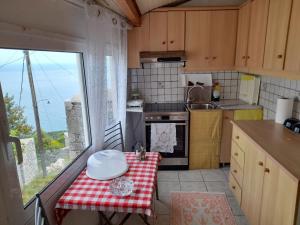 a small kitchen with a table with a red and white table cloth at Niki's view in Agriliá