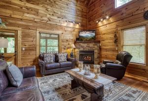 a living room with leather furniture and a fireplace at Camelot #266 in Pigeon Forge