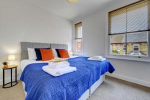 a bedroom with a blue bed with towels on it at The Dudley House I Spacious Executive House with Big Kitchen, Dining Space and Garden in Castle Quarter I eco-Short Term Let by SILVA in Bedford