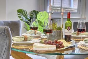 a table topped with glasses of wine and cheese at The Dudley House I Spacious Executive House with Big Kitchen, Dining Space and Garden in Castle Quarter I eco-Short Term Let by SILVA in Bedford