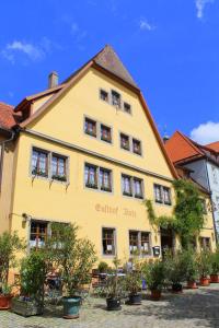 a yellow building with plants in front of it at Gasthof Butz in Rothenburg ob der Tauber