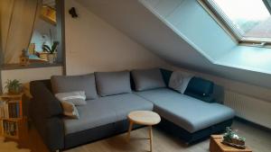 uma sala de estar com um sofá azul num sótão em Sous les Etoiles em Orchamps-Vennes
