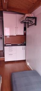 una cocina con armarios blancos y una cama en una habitación en Mansarda Nizza Tre, en Turín