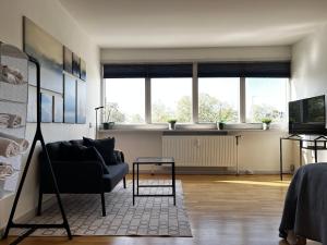 a living room with a couch and two windows at Studio Apartment Glostrup in Glostrup
