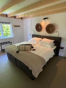 sypialnia z dużym łóżkiem z białą pościelą w obiekcie Bed & Breakfast Zeeuws Gelukkig w mieście Serooskerke