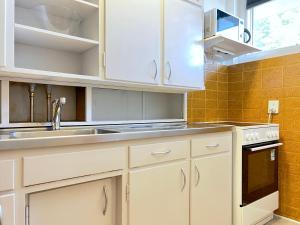 una cocina con armarios blancos y fregadero en Studio Apartment Glostrup, en Glostrup