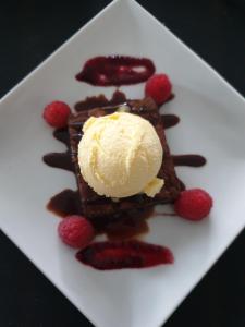 um prato branco com um waffle de chocolate com gelado e morangos em Loch Erisort Hotel em Balallan