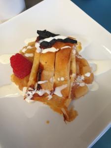 a white plate with a waffle with berries on it at Loch Erisort Hotel in Balallan