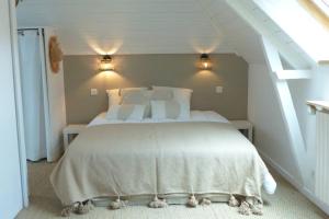 - une chambre mansardée avec un grand lit blanc dans l'établissement Maison de charme sur les quais port de St Goustan, à Auray