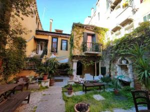 un patio de una casa con bancos y plantas en VENEZIA NATURALMENTE ideale per gruppi e famiglie, en Venecia