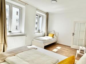 a bedroom with two beds and two windows at Design Apartment - Parking - Kingsize-Bett - 2x Bad - Zentrum in Hannover