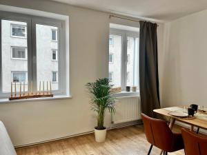 a dining room with a table and two windows at Design Apartment - Parking - Kingsize-Bett - 2x Bad - Zentrum in Hannover