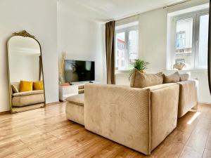 a living room with a couch and a mirror at Design Apartment - Parking - Kingsize-Bett - 2x Bad - Zentrum in Hannover