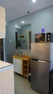 a kitchen with a stainless steel refrigerator and a counter at THE FIKA ROOM near MNL Airport - Scandi Studio Unit with Fast Wi-Fi & Netflix - Read Full Property Desc before booking in Manila