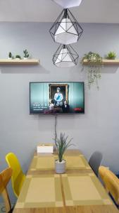 a room with a table with a tv on the wall at THE FIKA ROOM near MNL Airport - Scandi Studio Unit with Fast Wi-Fi & Netflix - Read Full Property Desc before booking in Manila