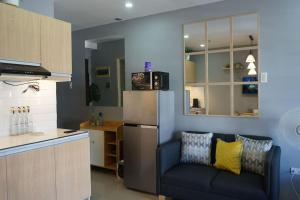 uma cozinha com um frigorífico e um sofá num quarto em THE FIKA ROOM near MNL Airport - Scandi Studio Unit with Fast Wi-Fi & Netflix - Read Full Property Desc before booking em Manila