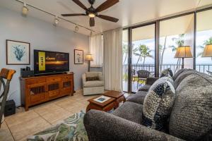 a living room with a couch and a flat screen tv at Kealia Resort 203 in Kihei