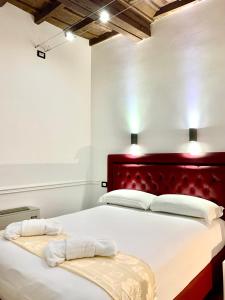 a bedroom with a large bed with a red headboard at Domus Ester in Rome