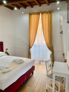 sypialnia z łóżkiem, biurkiem i oknem w obiekcie Domus Ester w Rzymie