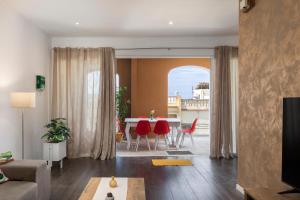 a living room with a table and red chairs at Spacious Luxury 3BR Apartment with Terrace & Open Views - Zurrieq, close to sea in Żurrieq