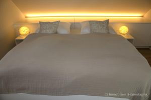 a bedroom with a large bed with two lamps on it at Designerloft See in Immenstaad am Bodensee